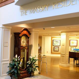 Entrance to The Wassery Residence featuring a grand clock and art displays.