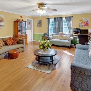 A cozy living room with wooden flooring, featuring sofas, a coffee table, and home decor.