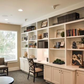 A cozy and organized home office with built-in bookshelves and a desk by the window.