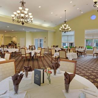 Elegant dining room with neatly arranged tables and chandeliers.