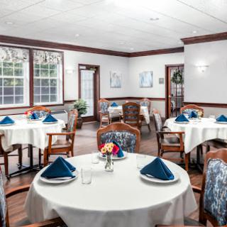 A well-set dining area featuring elegant tables with blue napkins and a cozy atmosphere.