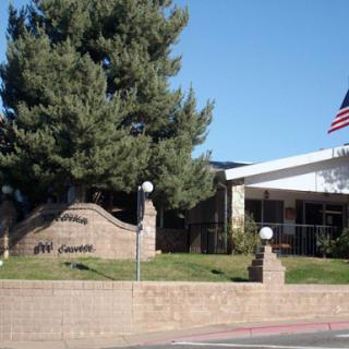 A view of a building with an American flag and landscaped grounds.