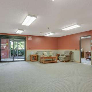 A spacious room with comfortable seating and large windows.