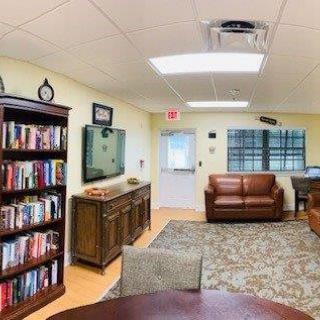 A cozy living room with a bookshelf, sofas, and a television.
