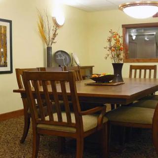 A cozy dining room with a wooden table and chairs, adorned with elegant decor and soft lighting.