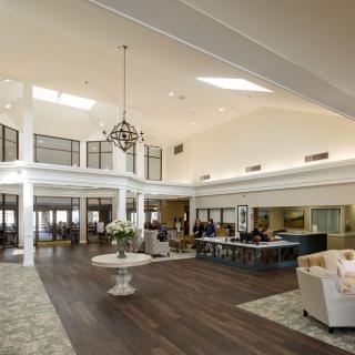 A spacious lobby with elegant furnishings and a chandelier.