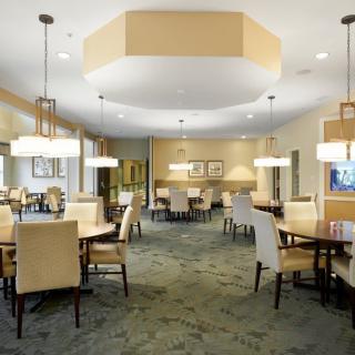 A spacious dining area featuring neatly arranged tables and chairs with elegant lighting.