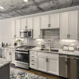 A modern kitchen featuring white cabinets, stainless steel appliances, and a subway tile backsplash.