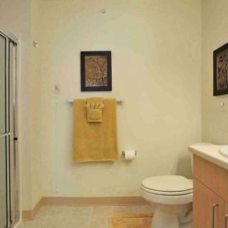 A clean and simple bathroom with a shower, toilet, and sink.