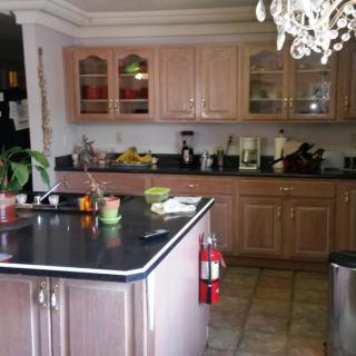 A kitchen with wooden cabinets, a central island, and a chandelier above.