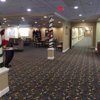 A spacious and well-lit lobby area with seating arrangements and a long hallway.