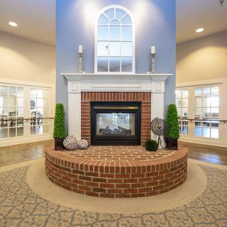 A cozy living room with a central brick fireplace and elegant decor.