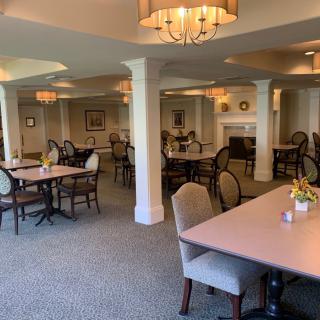 A spacious and elegantly decorated dining room with neatly arranged tables and chairs.