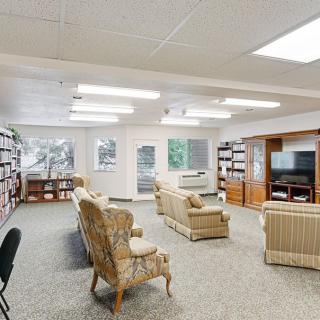 A cozy living room with bookshelves, comfortable seating, and a television.