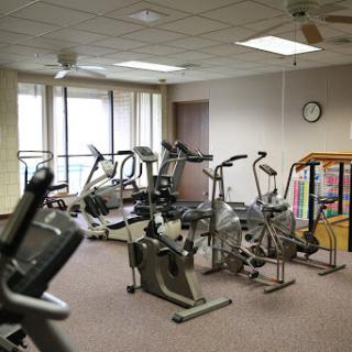 A well-equipped gym with various exercise machines and a bright, welcoming atmosphere.