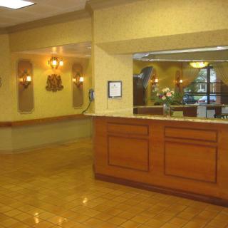 A hotel lobby with a reception desk and decorative lighting.