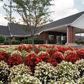 A beautifully landscaped building surrounded by vibrant flower beds.