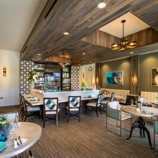 A modern restaurant interior with elegant dining furniture and stylish lighting.