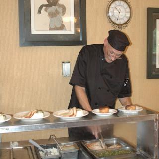A chef meticulously preparing plates of food in a restaurant setting.
