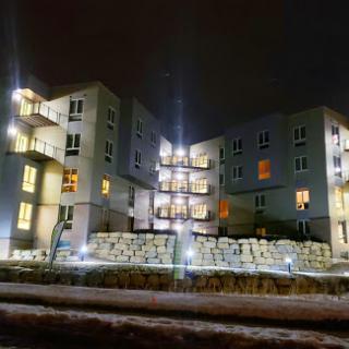 A modern residential building illuminated at night.