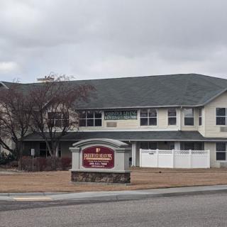 An overcast day at a two-story residential building with a sign in front.