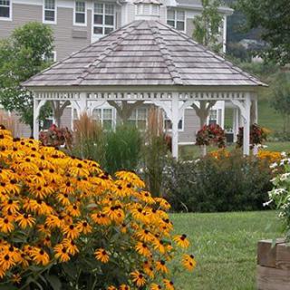 A charming gazebo surrounded by a vibrant garden full of colorful flowers.