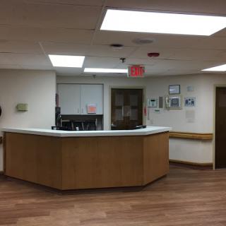 A view of the reception area in a medical facility, featuring a wooden front desk and a cozy ambiance.