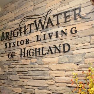 Sign for BrightWater Senior Living of Highland on a brick wall.