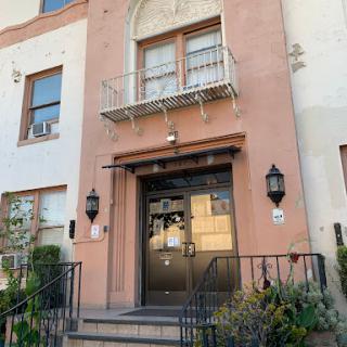 A charming residential building entrance with a decorated facade and balcony.
