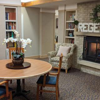 A cozy living room with a fireplace, bookshelves filled with books, and a decorated table at its center.