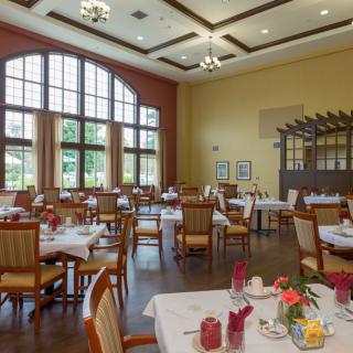 A well-lit dining area with multiple tables and chairs arranged neatly.