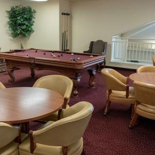 A cozy lounge with a billiards table and comfortable seating.