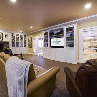 A cozy living room featuring a home theater setup with bookshelves and comfortable seating.