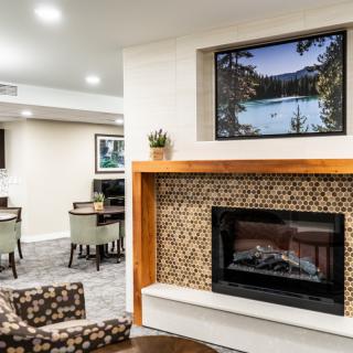 A cozy living room with a fireplace, seating area, and decorative artwork.