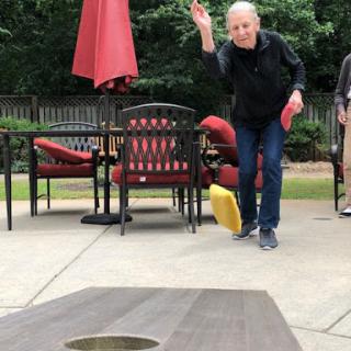 A lively game of cornhole in a backyard setting, showcasing friendly competition and outdoor fun.