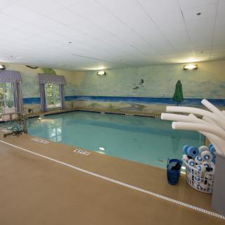An indoor swimming pool equipped with floatation devices and pool amenities.