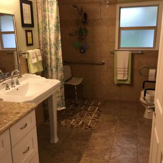 A well-organized bathroom with a sink, shower, and towel rack.