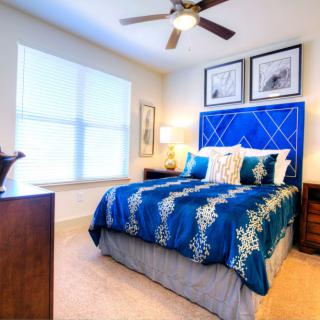 A modern bedroom with blue bedding and stylish decor.
