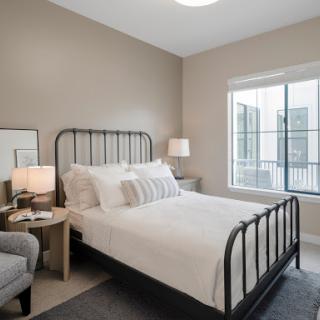 A cozy modern bedroom featuring a stylish metal bed frame and soft decor.
