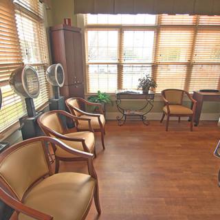 A cozy waiting room with wooden floors and natural light streaming through large windows.