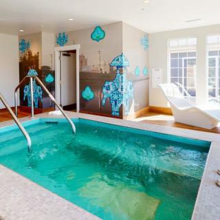 A luxurious indoor spa area with a small pool and reclining chairs, designed for relaxation.