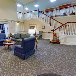 A spacious lobby with comfortable seating and elegant stairs.