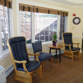 A cozy waiting area with chairs and natural lighting from large windows.