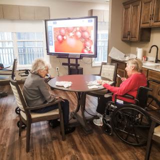 Seniors engaging in a group activity featuring interactive technology in a care facility.