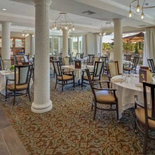An elegant dining area with neatly arranged tables and chairs, featuring soft lighting and sophisticated decor.