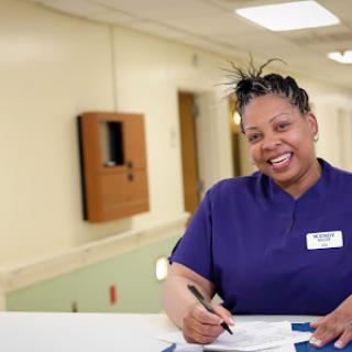 A cheerful nurse taking notes at the hospital.