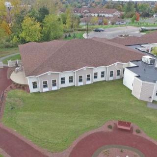 Aerial view of a building surrounded by greenery and pathways.