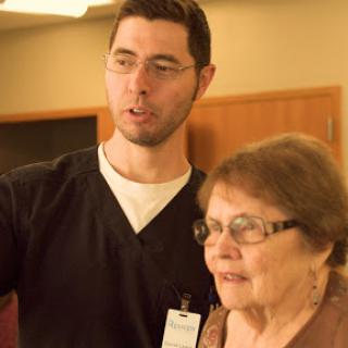 A healthcare professional interacts with an elderly woman, providing assistance and support.