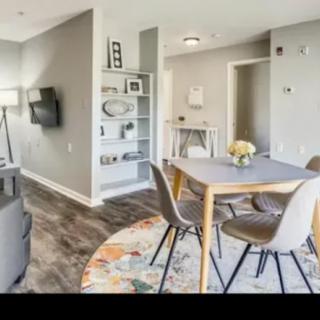A modern living room with a dining table set, open shelving, and stylish decor.