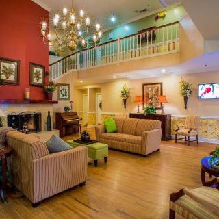 A cozy and elegantly designed living room featuring modern furniture, a chandelier, and a staircase.